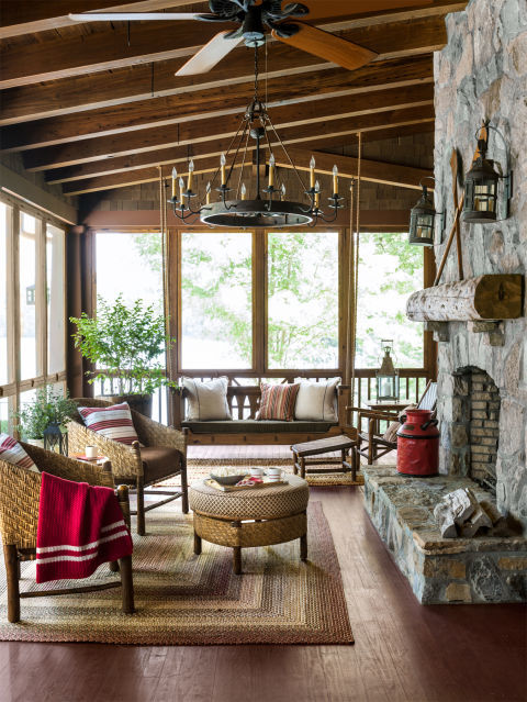 This inviting space follows a foolproof formula for cabin coziness: Start with a rusty-red painted floor and a massive stone fireplace, add a pair of iconic Old Hickory hoop chairs and a cozy rug, and finish it off with a 6-foot-long custom porch swing. 