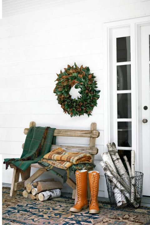 Country Willow throws and a wire basket filled with firewood adorn this front porch.
