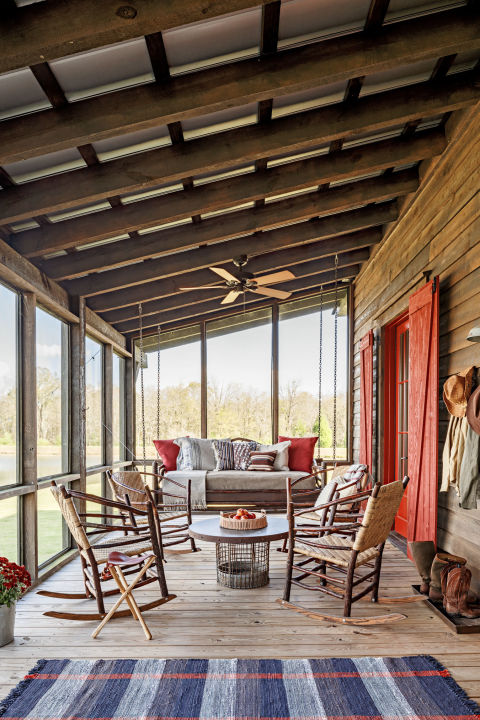 Red comes in all forms on this porch: pillows, barn doors, florals, and a stripe in the throw rug. Together, they create a cozy, rustic aesthetic that stands out in fall, but could also last throughout all the seasons.
