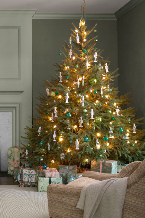 Hobby Lobby toy soldiers, painted white, along with green globes from HiHo Antiques decorate the Norwegian spruce in this Connecticut farmhouse.