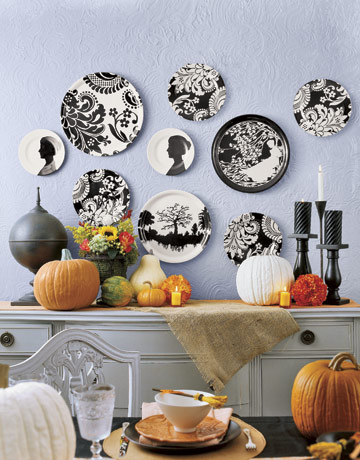 black and white graphic plates on a wall above a halloween decorated table