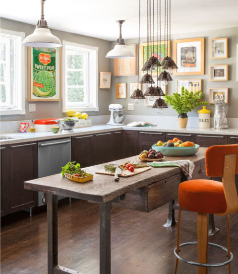 Carrara marble upgrades Ikea cabinets in the kitchen of this California cottage. Task lighting comes in the form of suspended Edison bulbs, covered with Victorian wire shades. The homeowner framed a 1960s supermarket ad as a cheeky homage to Andy Warhol's soup can. The walls are painted Coventry Gray by Benjamin Moore. 