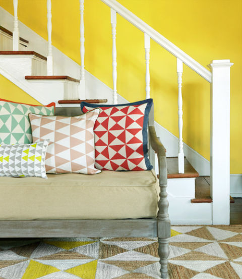 Classic quilt motifs are suddenly popping up everywhere. Pillows featuring geometric shapes (Mint Throw Pillow and Red Throw Pillow, $49; cali sea.com; Neon Bolster, $45; earthcadets .etsy.com; Taupe Throw Pillow, $73;ferm livingshop.com) and a jute-and-cotton rug (surya.com) displaying triangle designs— simplified takes on traditional quilt patterns—make this entryway pop. 