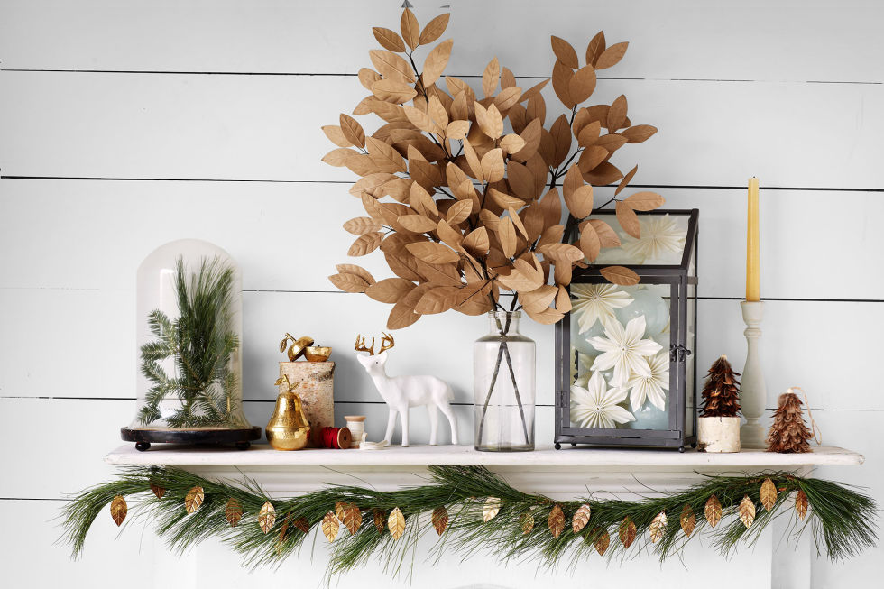 Equal parts glitzy and grounded, this scene pairs brass fruit votives with a deer who dares to wear gilded antlers, amid paper and metal leaves. Paper flowers and greenery sprigs seem extra-special under glass.
(The HomePort Collections candles, from $17 each; The Nest Interiors, 918-530-5580. Papier-mâché deer, $30; Cody Foster & Co., 800-595-5907 for stores. Paper branches, $19 each; westelm.com. Leaf garland, $19; 9'L; olivemanna.com. HomArt greenhouse, $56; 8"W × 15"H; areohome.com. Roost paper poinsettias, $10 each; SoLo, 858-794-9016)