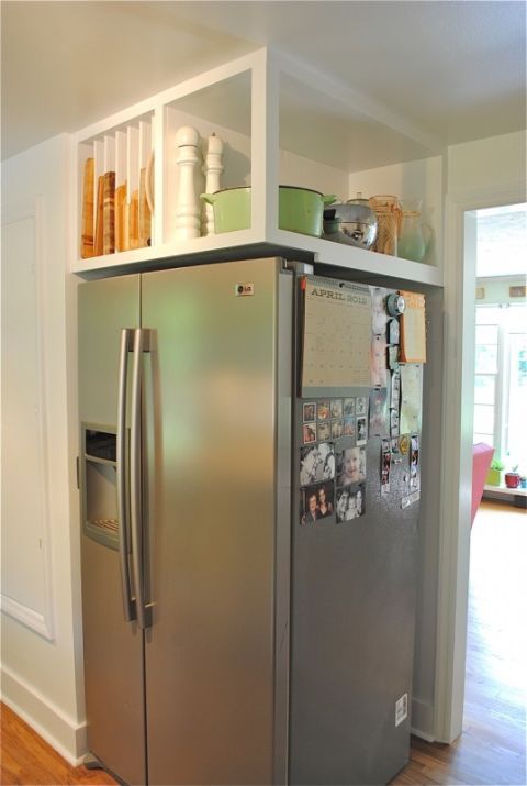 Here, an awkward corner refrigerator becomes super handy with built-in overhead shelving. An open area holds large items like a slow cooker, while  slotted sections keep cookie sheets and cutting boards in place.
See more at Bev Cooks »
