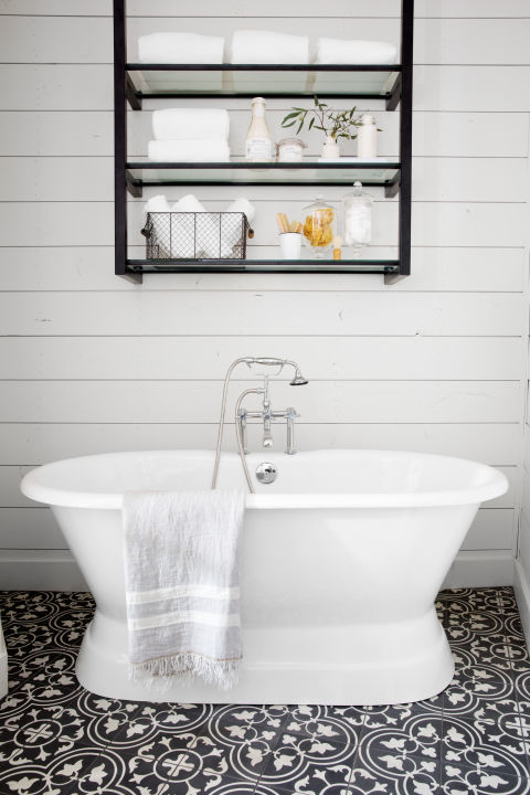 "As much as I love white subway tile and white shiplap, I know when there's too much white in a space. This floral tile is bold, but the black color keeps it feeling classic. The open metal shelves above the tub give the room a touch of 'modern farmhouse' that you see throughout the home." 